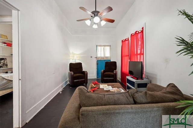 living room with baseboards, wood finished floors, and a ceiling fan