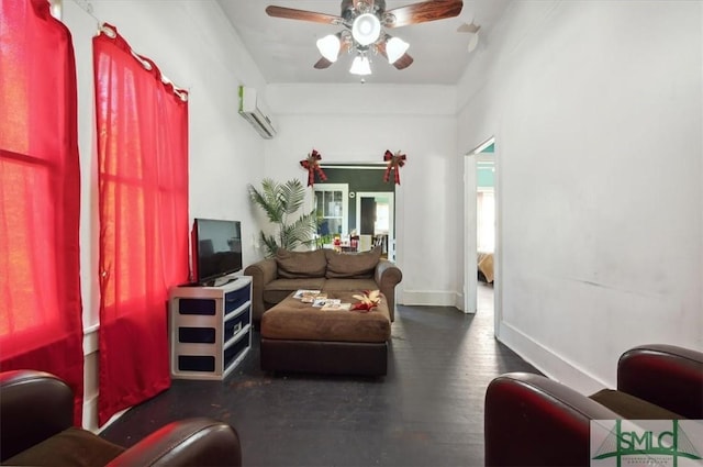 living area with wood finished floors, baseboards, a wall mounted air conditioner, and ceiling fan