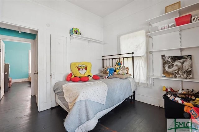 bedroom with baseboards and wood finished floors