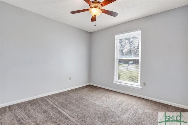 carpeted spare room with a ceiling fan, baseboards, and a textured ceiling