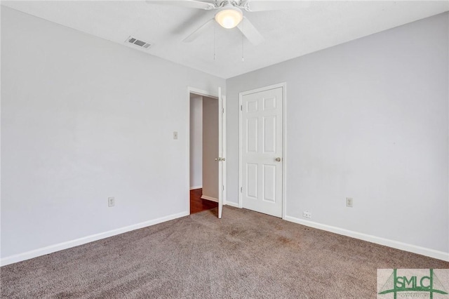 carpeted spare room featuring a ceiling fan, visible vents, and baseboards