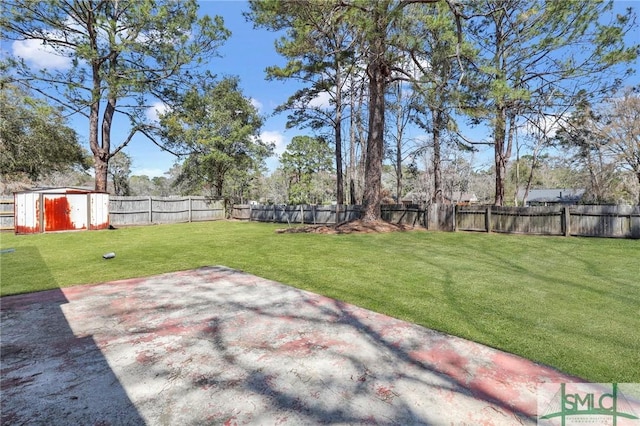 view of yard with a patio area, a storage shed, an outbuilding, and a fenced backyard