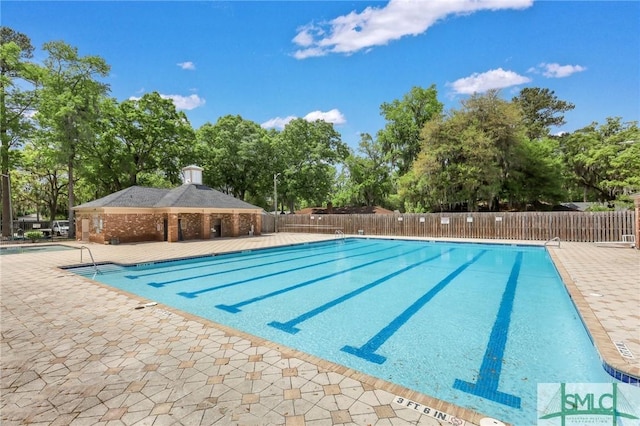 community pool featuring a patio and fence