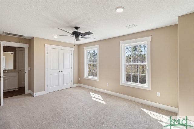 unfurnished bedroom featuring carpet, visible vents, a closet, and baseboards