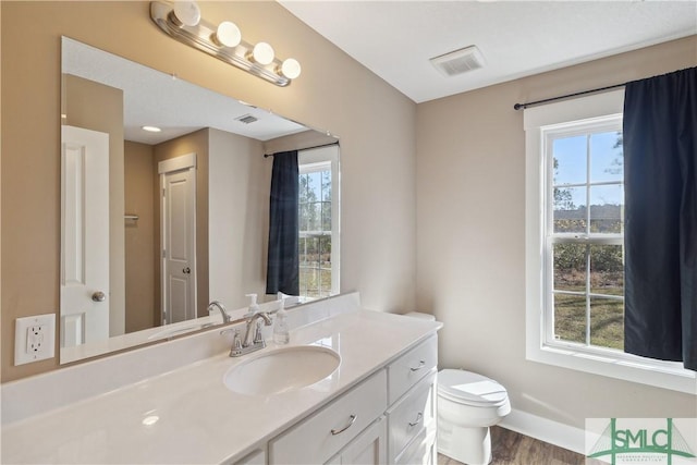 bathroom with visible vents, a healthy amount of sunlight, and toilet