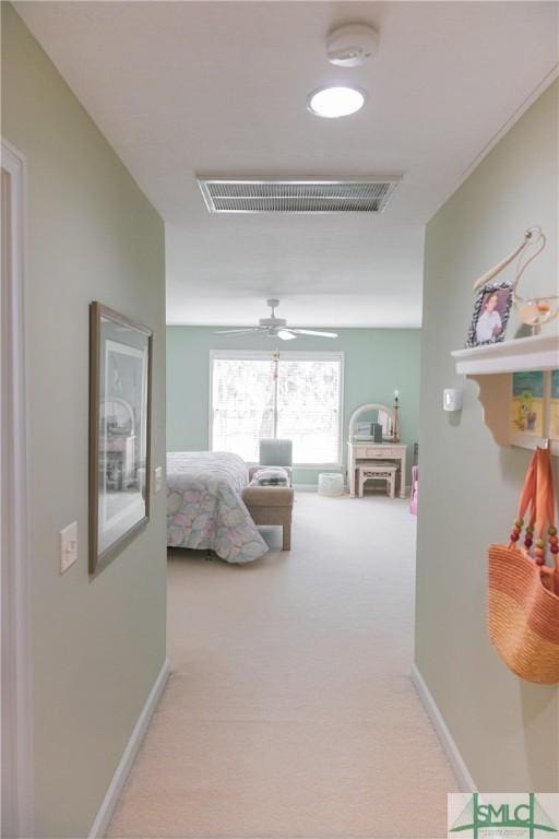 hall with carpet flooring, baseboards, and visible vents