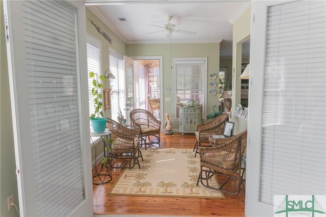 sitting room featuring visible vents, crown molding, ceiling fan, and wood finished floors