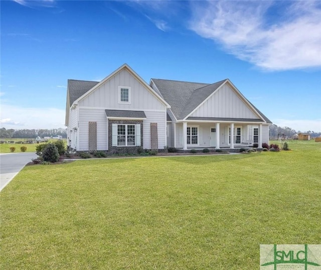 view of front of property with a porch, board and batten siding, and a front yard