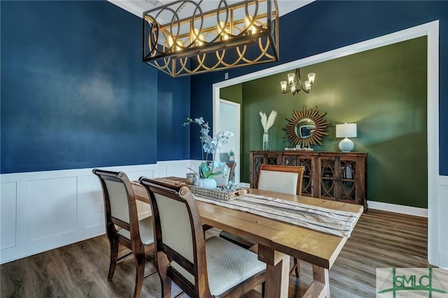 dining room with wainscoting, an inviting chandelier, and wood finished floors