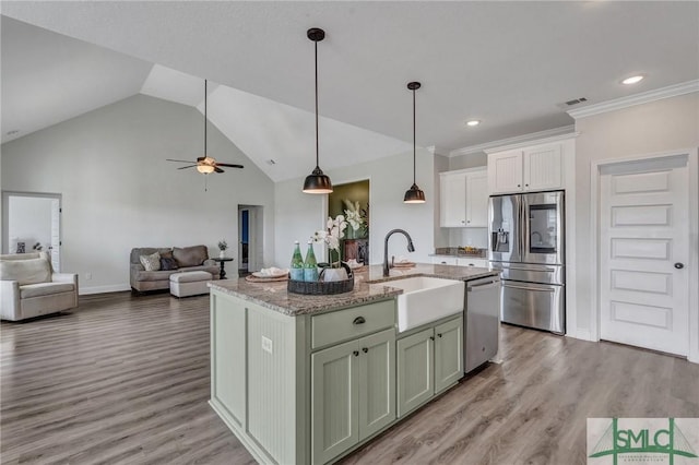 kitchen with a sink, light wood-type flooring, open floor plan, and stainless steel appliances