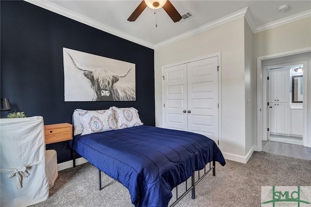 carpeted bedroom with a closet, visible vents, crown molding, and baseboards