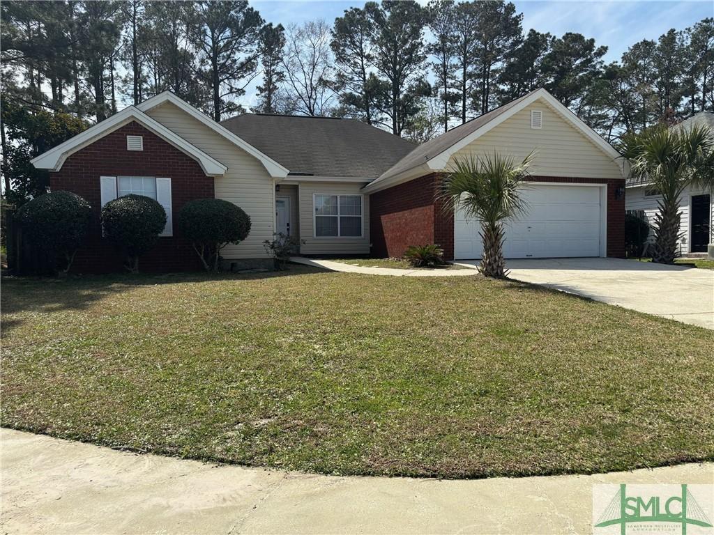 single story home featuring concrete driveway, an attached garage, brick siding, and a front yard