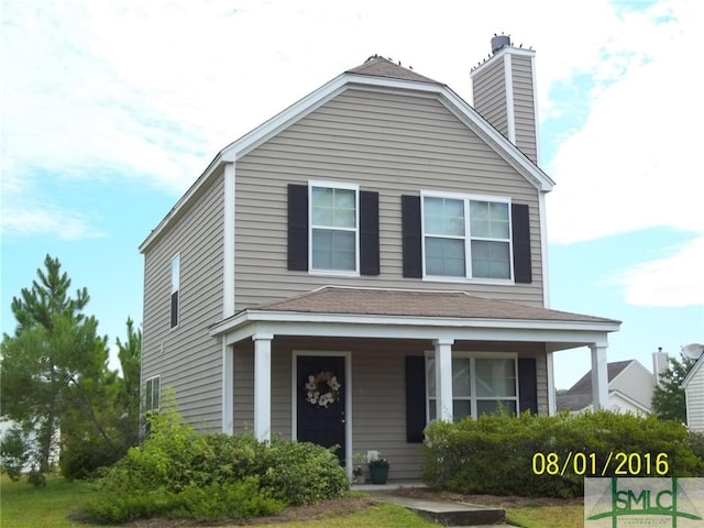 view of front of house featuring covered porch, roof with shingles, and a chimney