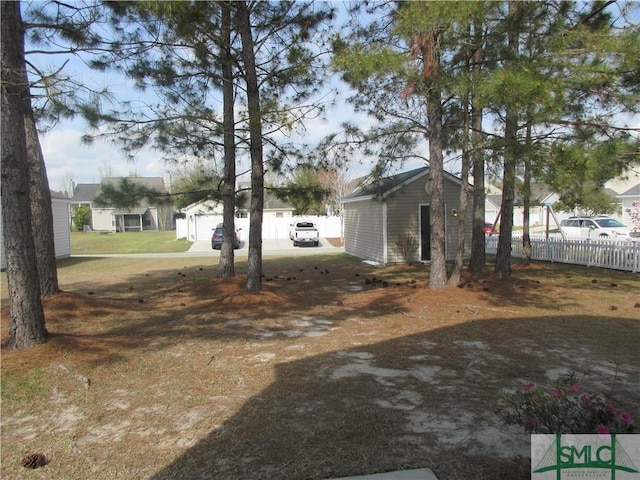 view of yard featuring an outdoor structure and fence