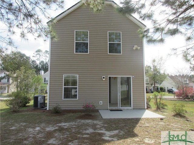 rear view of property featuring a patio, central AC, and a lawn
