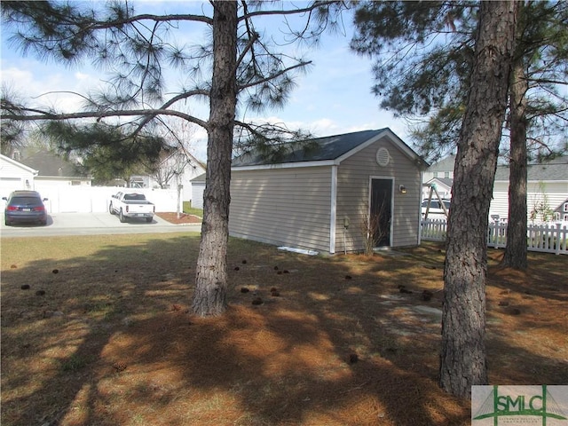 view of outdoor structure featuring an outbuilding and fence