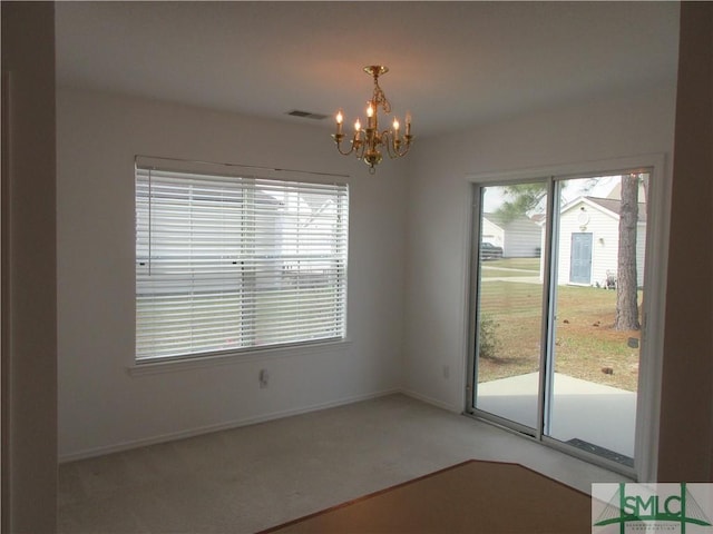 unfurnished dining area with an inviting chandelier, baseboards, light colored carpet, and visible vents