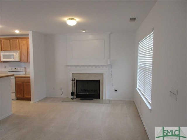unfurnished living room with a fireplace with flush hearth, baseboards, light colored carpet, and visible vents