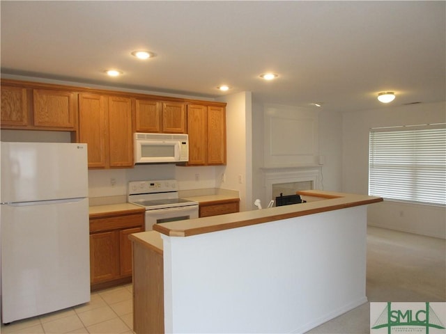 kitchen featuring light countertops, recessed lighting, brown cabinets, and white appliances