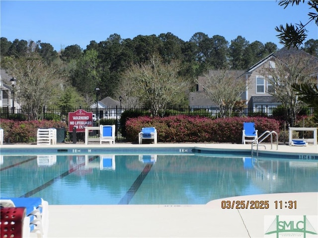 community pool featuring grilling area and fence