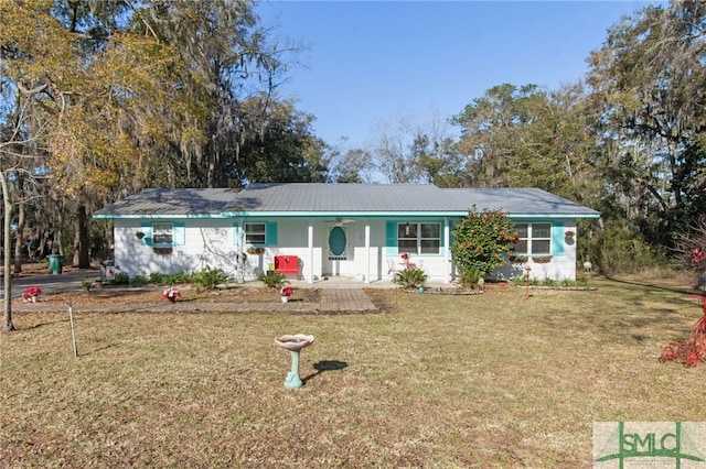 ranch-style home featuring metal roof and a front yard