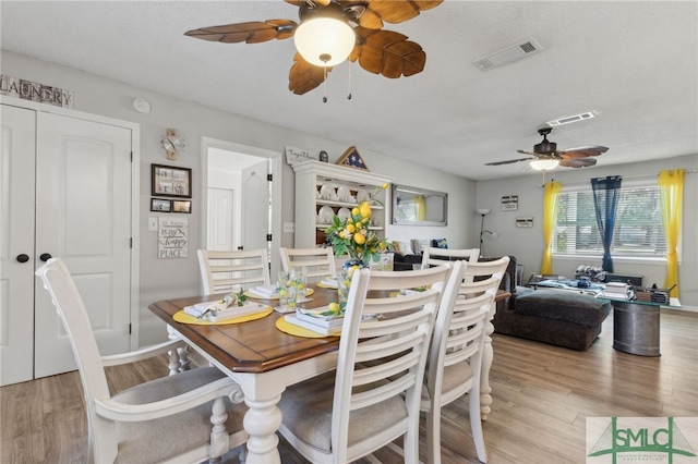 dining room with visible vents, light wood-style floors, and a ceiling fan