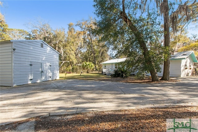 view of home's exterior with driveway and an outdoor structure