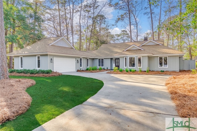 ranch-style house featuring a garage, a chimney, concrete driveway, and a front yard