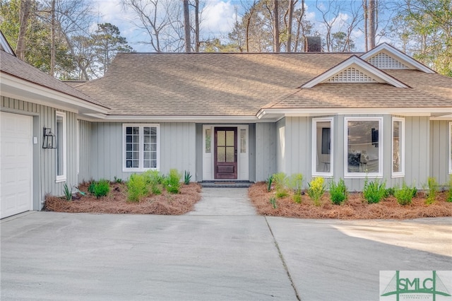 view of front of house featuring a chimney, board and batten siding, a shingled roof, and an attached garage