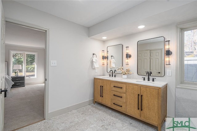 full bath with a sink, baseboards, and a healthy amount of sunlight