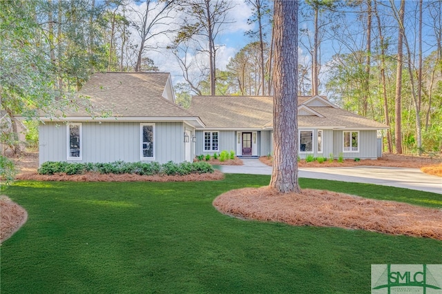 view of front of property with a shingled roof and a front lawn