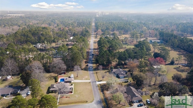 birds eye view of property featuring a forest view