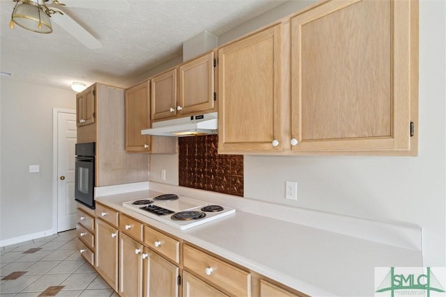 kitchen featuring oven, white electric stovetop, under cabinet range hood, and light brown cabinetry