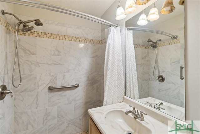 full bath with tiled shower and vanity