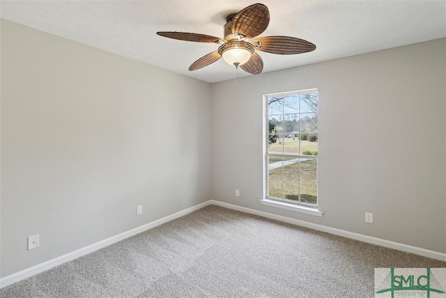 carpeted spare room with a ceiling fan and baseboards