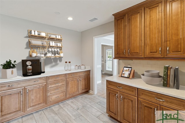 bar with light wood-type flooring, visible vents, backsplash, recessed lighting, and baseboards