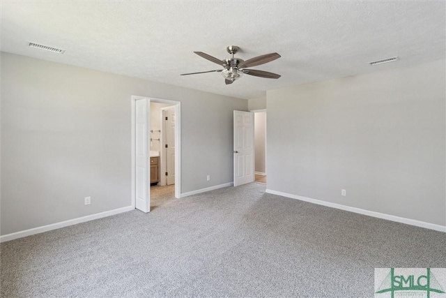 unfurnished bedroom featuring light colored carpet, baseboards, visible vents, and a textured ceiling