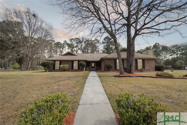 view of front of home featuring brick siding and a front lawn