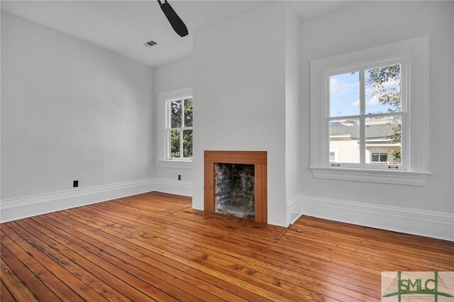114 W Bolton St, Savannah, GA 31401 - unfurnished living room with a fireplace, wood-type flooring, baseboards, and ceiling fan