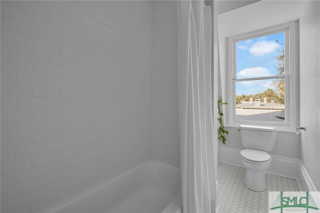114 W Bolton St, Savannah, GA 31401 - bathroom featuring toilet, healthy amount of natural light, shower / bathtub combination with curtain, and baseboards
