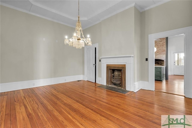 114 W Bolton St, Savannah, GA 31401 - unfurnished living room with a fireplace with flush hearth, hardwood / wood-style floors, a chandelier, crown molding, and a high ceiling