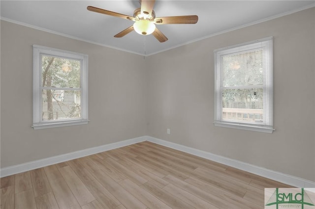 empty room featuring light wood-style floors, baseboards, and ornamental molding