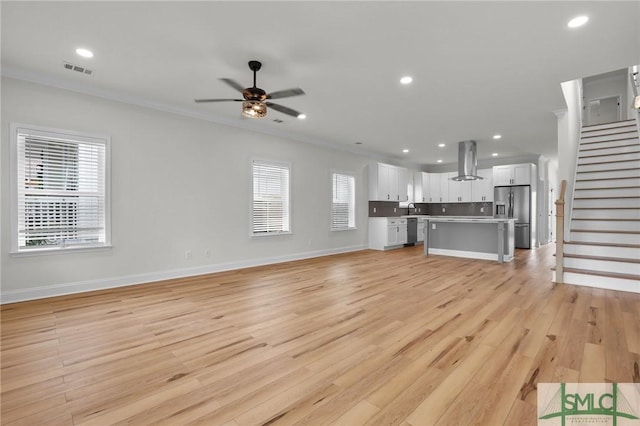 unfurnished living room with stairway, visible vents, light wood finished floors, recessed lighting, and ceiling fan