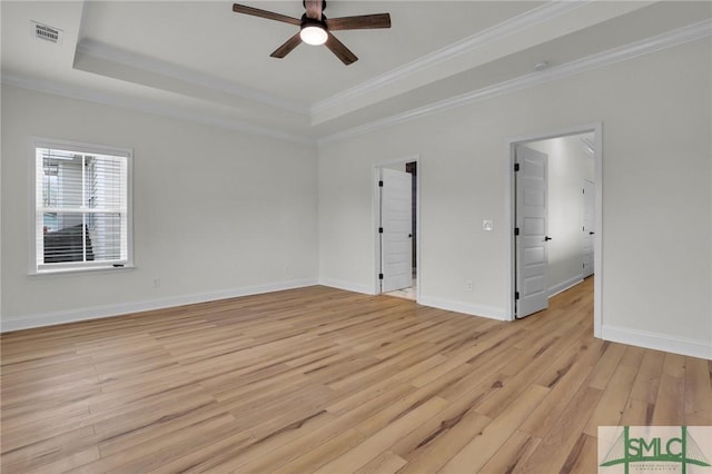 unfurnished room with visible vents, baseboards, ceiling fan, light wood-style floors, and a raised ceiling