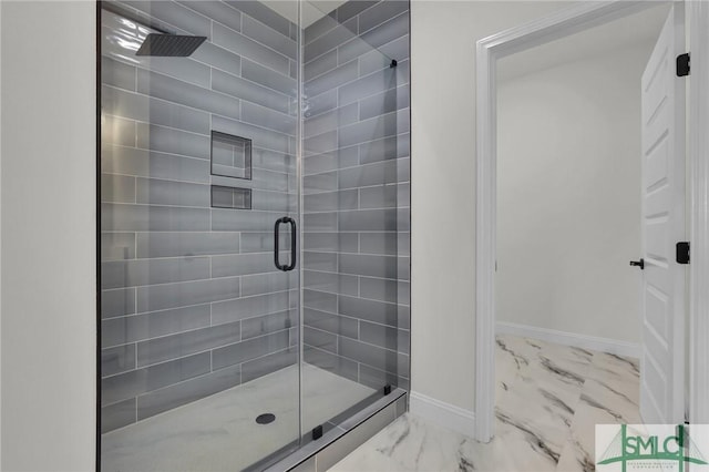 full bathroom featuring marble finish floor, a shower stall, and baseboards