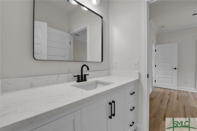 bathroom with vanity, baseboards, and wood finished floors