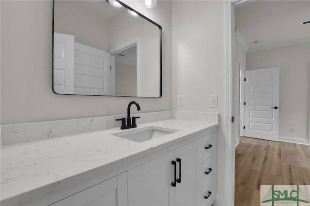 bathroom featuring vanity, wood finished floors, and baseboards