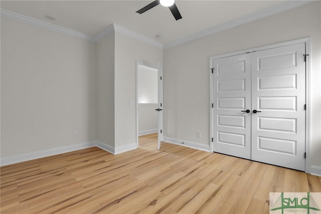 unfurnished bedroom with light wood-type flooring, a closet, crown molding, baseboards, and ceiling fan