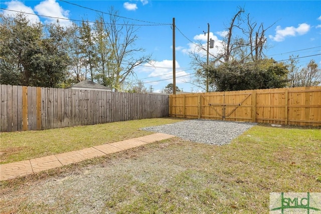 view of yard with a fenced backyard and a gate