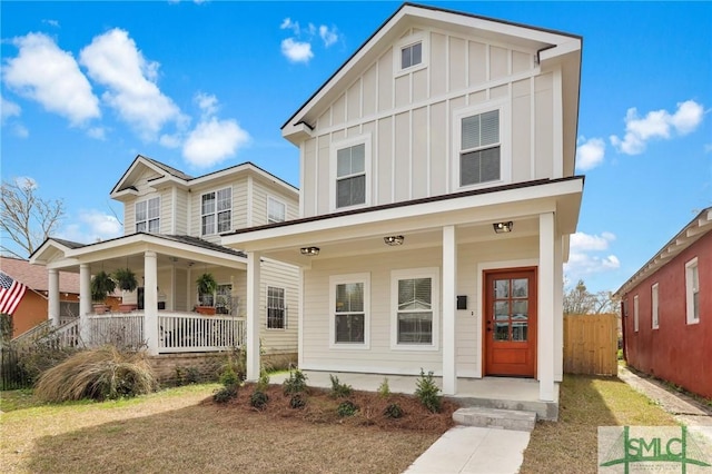 view of front of home with a porch, board and batten siding, and fence